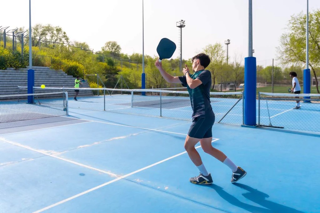 Player serving a pickleball